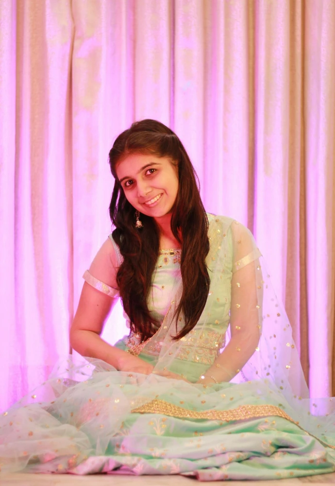 a woman in a green dress sitting on a bed